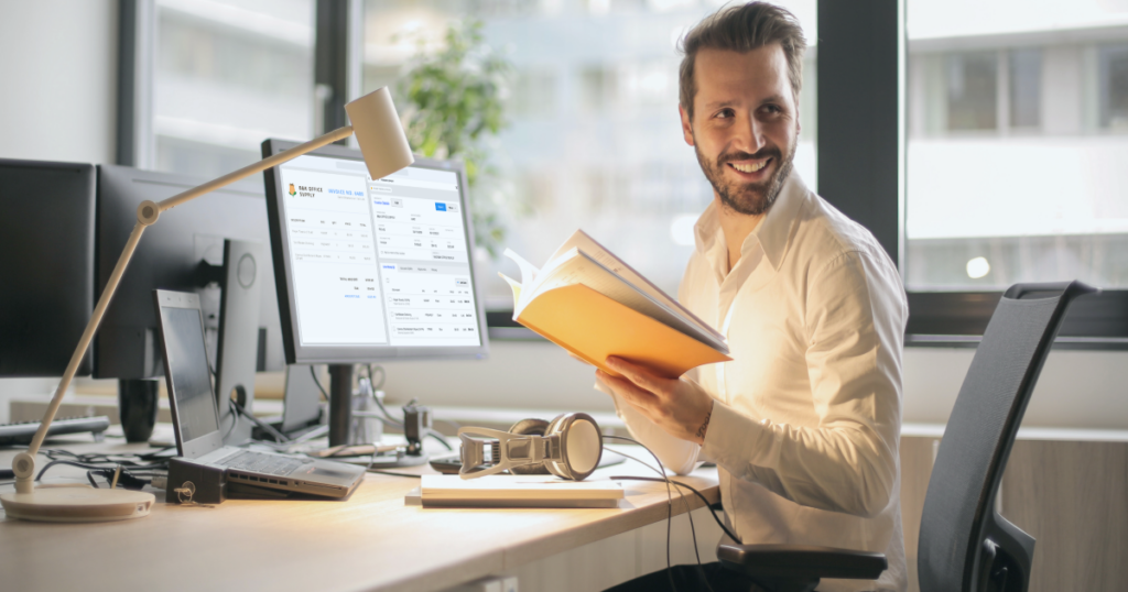 Accounting smiling at his desk while using invoice ap automation software
