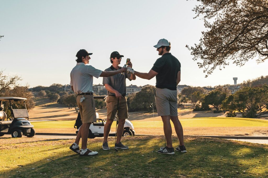 Picture of a group of golfers raising a toast with beverages at a golf course within a country club.
