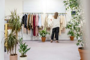 woman searches rack of clothing at a retail store