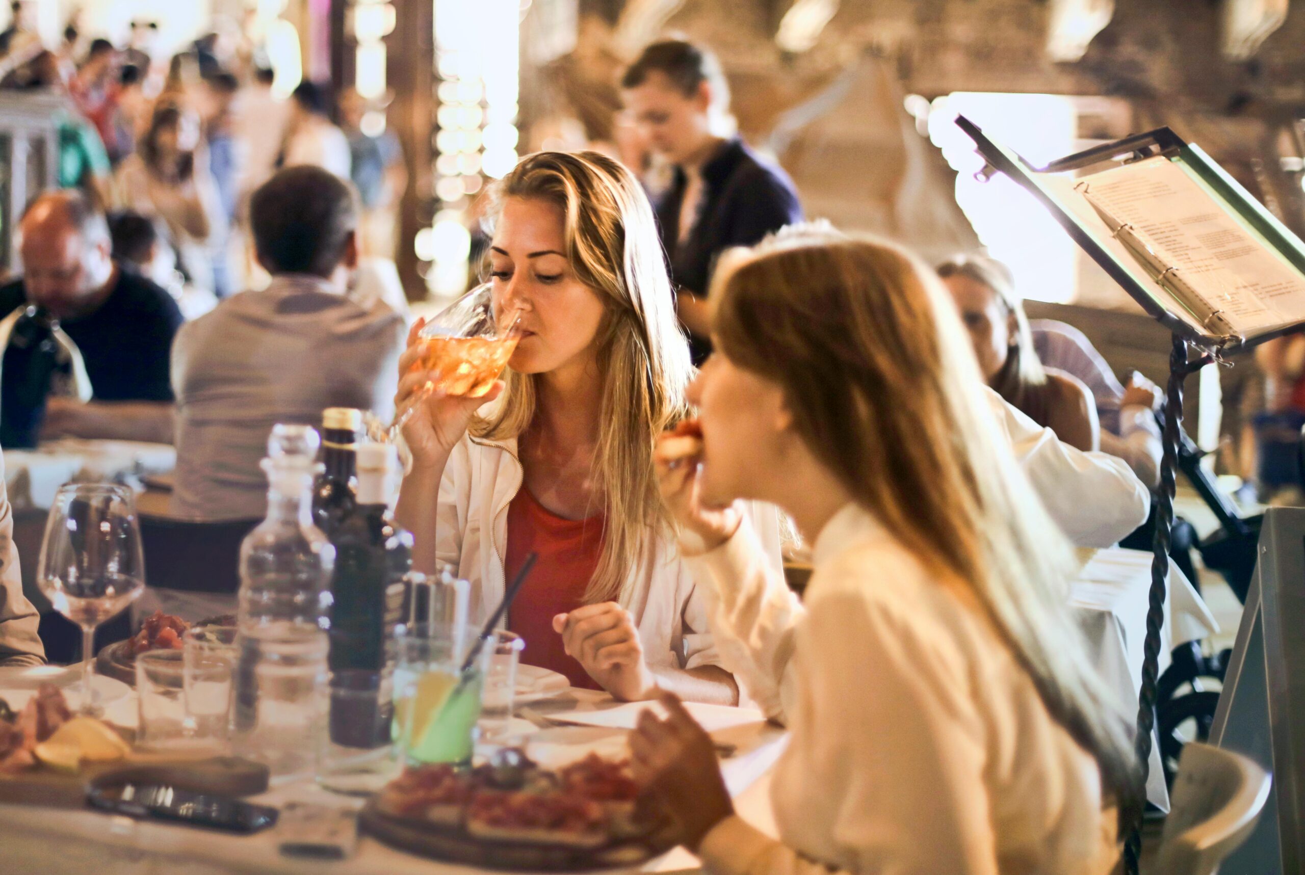 two women eating in a busy restaurant setting