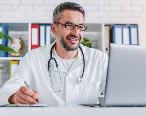 doctor with stethoscope working on laptop