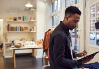 male small business owner checks stock in shop