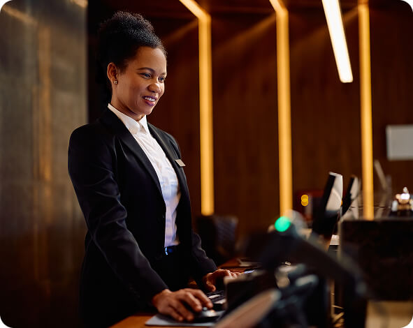 receptionist working at hotel front desk computer